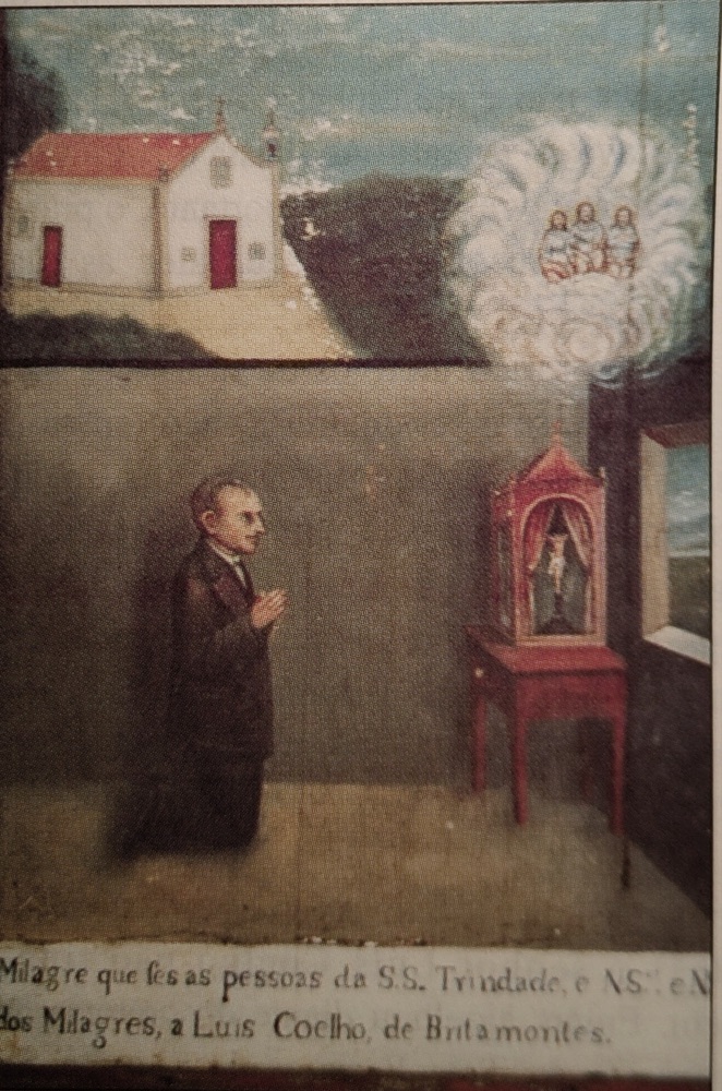 Pintura de Luís Coelho ajoelhado em oração diante de um oratório, com a Capela de Britamontes e a Santíssima Trindade representadas acima