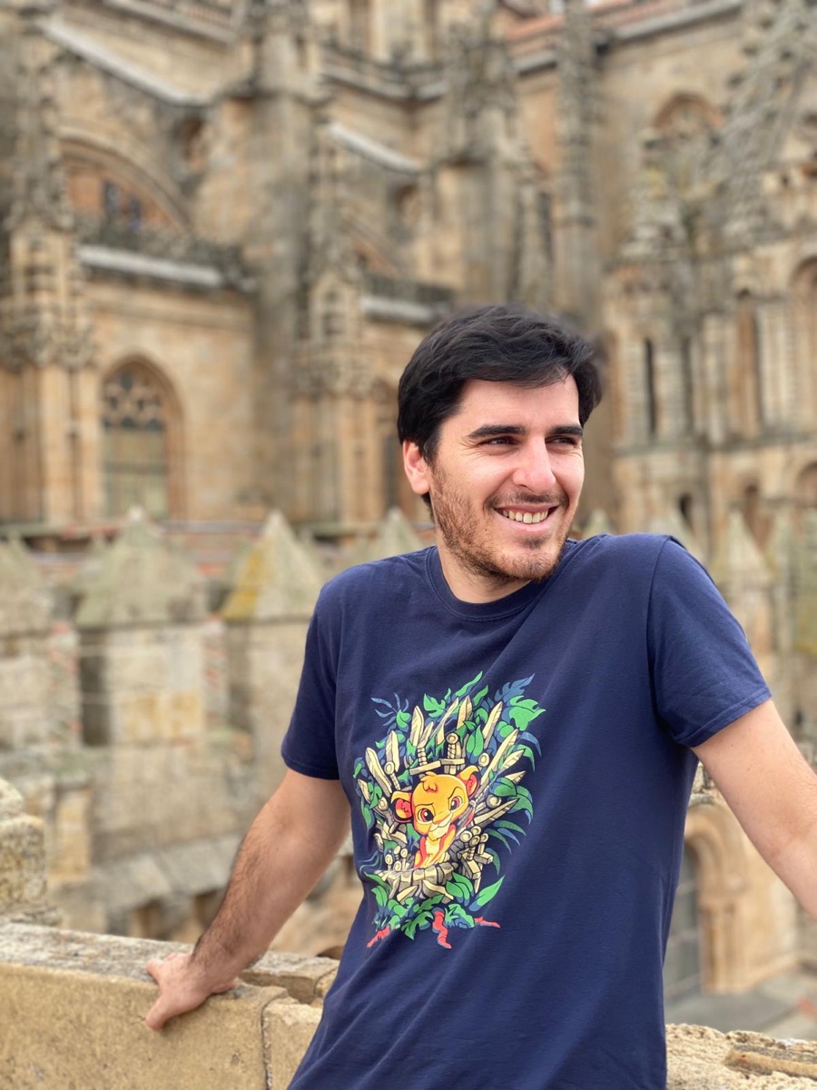 José a sorrir, junto a um edifício de pedra.