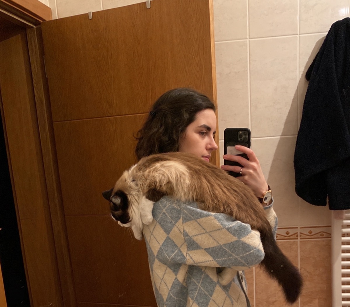 Reflexo da Rafaela ao espelho, com um gato ao colo.